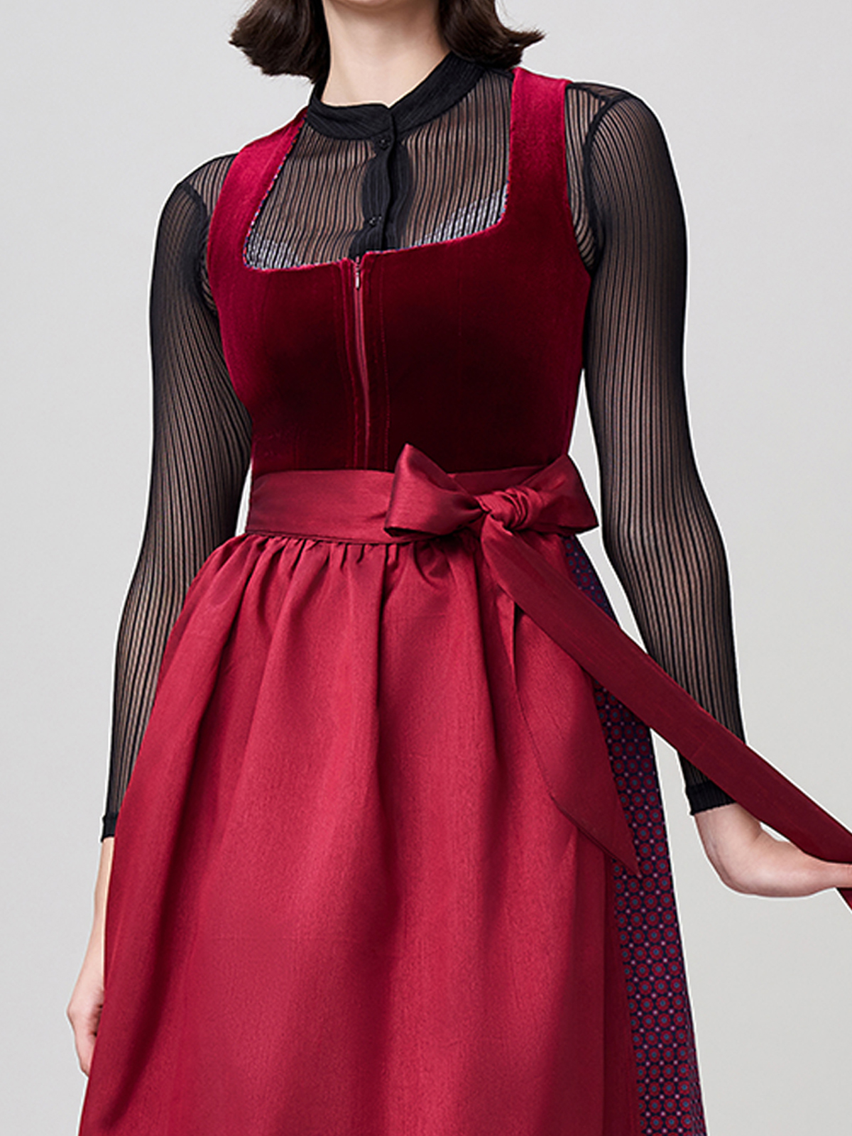 Ein elegantes rotes Dirndl mit traditioneller Schürze