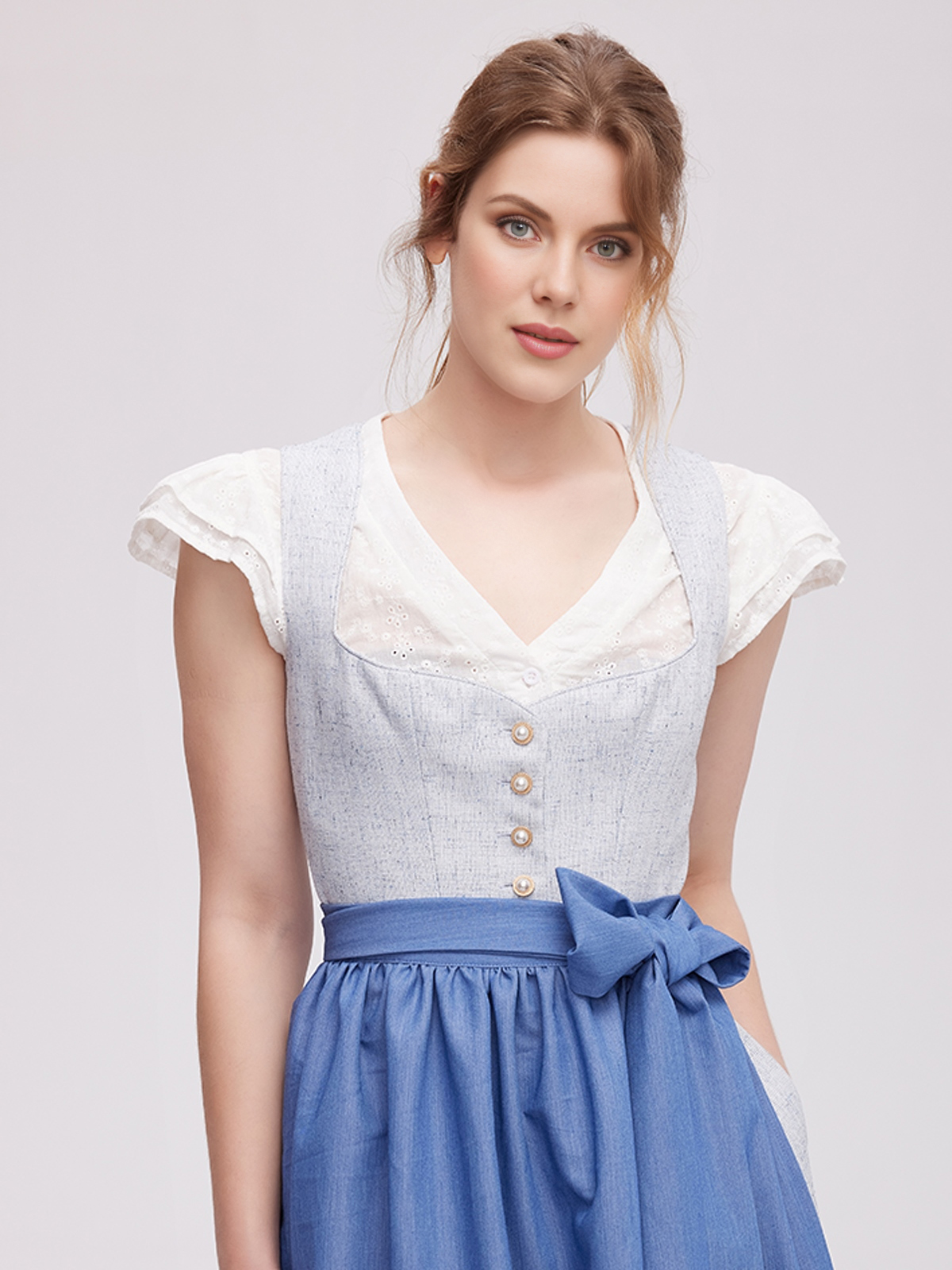 Strahlendes oranges Dirndl mit floraler Schürze
