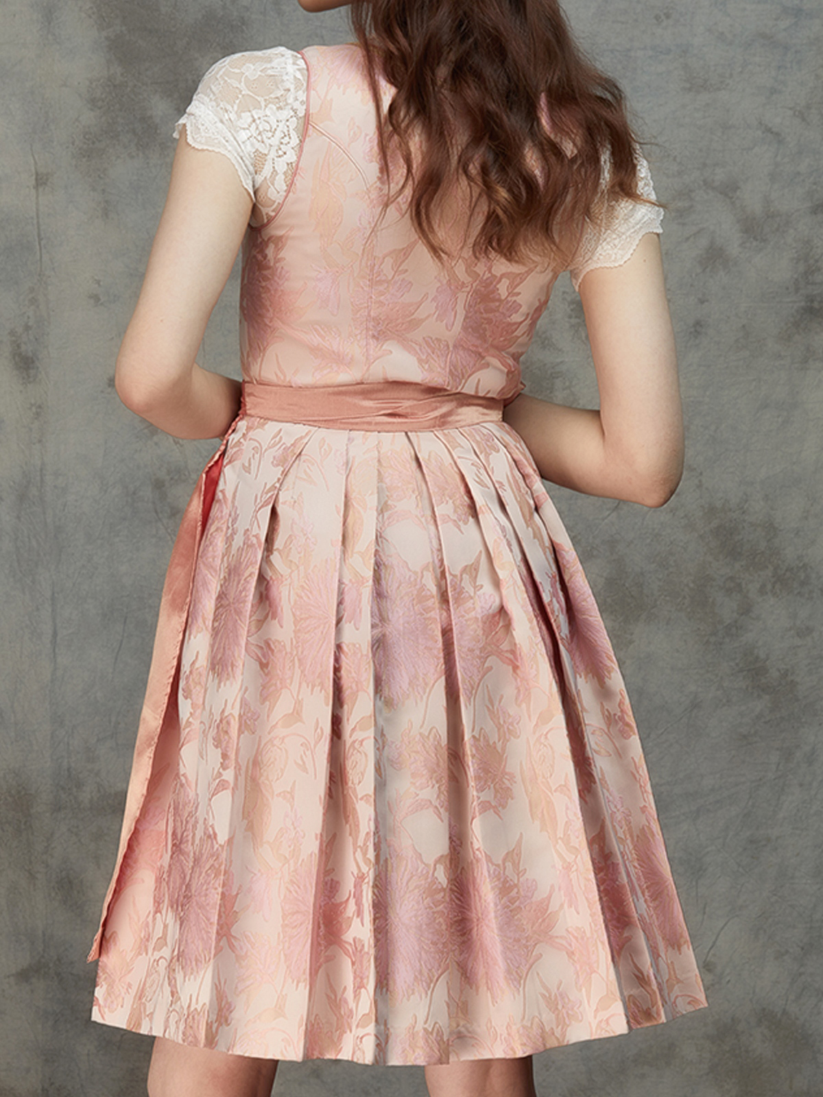 Modernes rosafarbenes Dirndl mit Spitzenbluse und Schürze